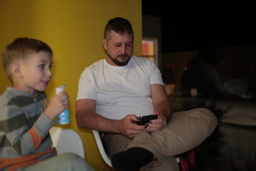 Father and son relaxing on chairs at home