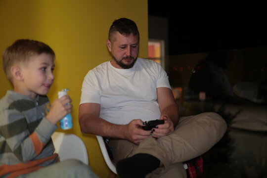 Father and son relaxing on chairs at home