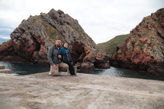 Father and son exploring coastal landscape on pier