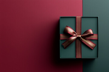 Elegant green gift box with burgundy ribbon on two-tone background  