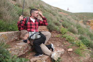 Father and son resting during outdoor hiking adventure