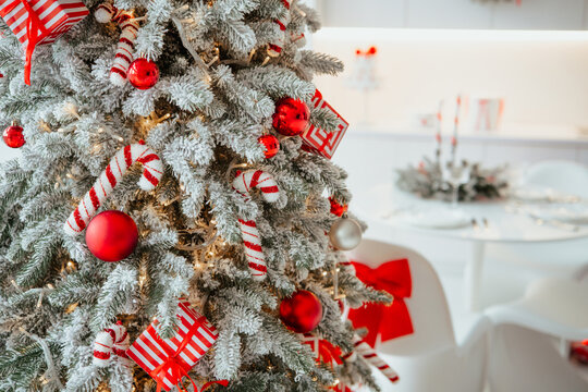 Flocked evergreen tree decorated with red baubles candy canes and gift boxes - Powered by Adobe