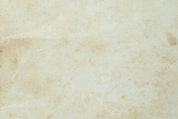 Macro texture of ancient book paper with aged fibers and natural wear. Warm vintage surface ideal for backgrounds, antique themes, history, design and creative projects