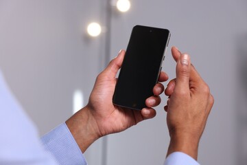 African-american man using smartphone in office, closeup