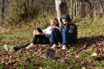 Women relaxing under a tree in autumn