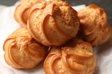Delicious golden profiteroles on table, closeup view