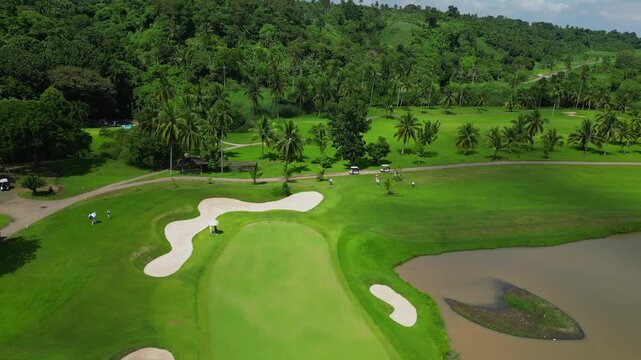 A circling aerial of Canlubang Golf and Country Club showing golfers on the fairways with tropical trees in Calamba Laguna, Philippines