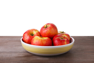 Ripe red apples in bowl on wooden table against white background, closeup