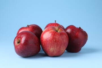 Ripe red apples on light blue background, closeup