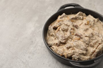 Tasty beef Stroganoff in baking pan on grey table, closeup. Space for text