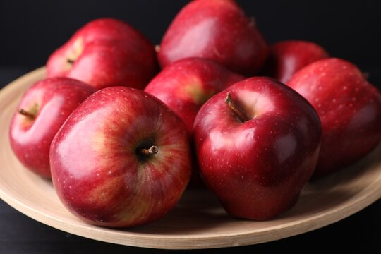 Ripe red apples on table against black background, closeup