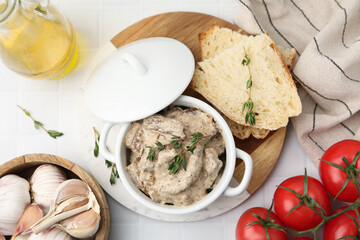 Tasty beef Stroganoff with thyme in casserole and ingredients on white tiled table, flat lay