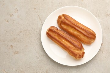 Tasty eclairs on light table, top view. Space for text