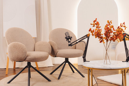 Relaxed podcast setup with stylish chairs and microphones in a cozy space for engaging conversations - Powered by Adobe