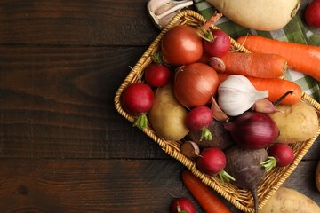 Different raw vegetables on wooden table, flat lay. Space for text