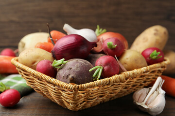 Different raw vegetables on wooden table, closeup