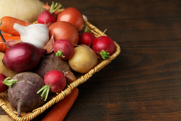Different raw vegetables on wooden table, closeup. Space for text
