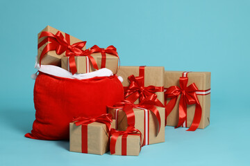 Santa Claus bag with Christmas gifts on light blue background