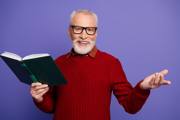 Elegant elderly man with white hair glasses reads book in red sweater smiling purple background for lifestyle advertising senior education themes
