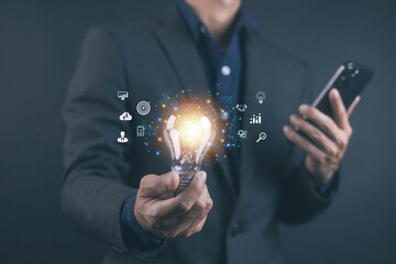 Business innovation concept with a businessman holding a glowing light bulb and digital icons representing ideas, strategy, analytics, technology, and creativity for modern corporate solutions.