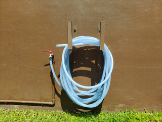 The faucet attached to the hose has a ring fixed to the wall.