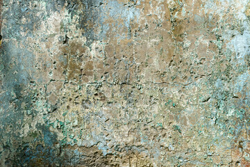 Wall texture of an old building with peeling paint and layered decay