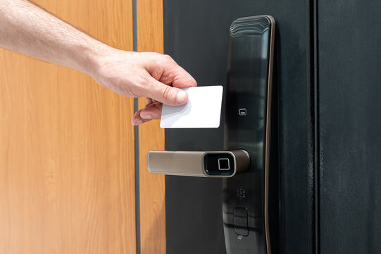 Close-up of RFID card near smart lock on door, concept of secure access in smart home
