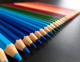 Assorted colorful pencils aligned in a graduated spectrum, leading to a point on a dark surface