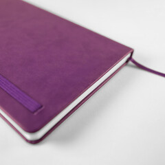 Close-up purple notebook mockup in minimal white setting
