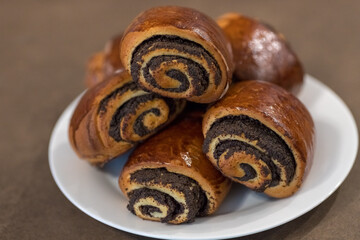 Tasty buns with poppy seeds on the plate. Delicious baked goods. Sweet dessert