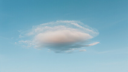 A single cloud floating in a clear blue sky, symbolizing calmness and tranquility in nature.