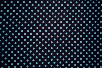 Black textile with a regular turquoise polka dot pattern.