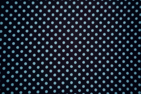 Black textile with a regular turquoise polka dot pattern.