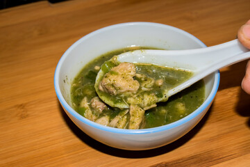 Spinach or Palak chicken soup served on dinner table.	