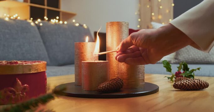 Christmas Home Decorations &ndash; A Woman is Lighting the Second Candle of a Modern Advent Arrangement