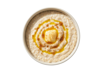 Isolated breakfast bowl of oatmeal topped with butter and cinnamon in ceramic bowl, top view