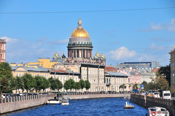 Golden dome cathedral and historic riverside architecture with tour boats on sunny summer day