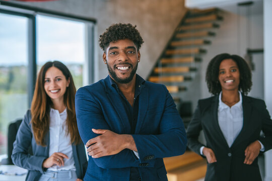 Diverse business professionals standing with confidence in modern office