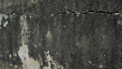 Aged concrete surface displays significant weathered texture and a prominent horizontal fissure