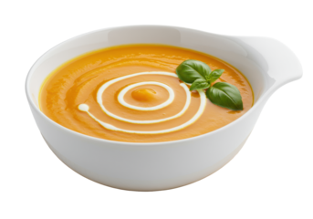Vibrant orange creamy pumpkin soup with cream swirl and green basil in a sleek white ceramic bowl on a wooden base, isolated on a white background with copy space, concept of gourmet healthy food