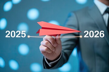 2025 to 2026 transition concept with businessman launching red paper airplane