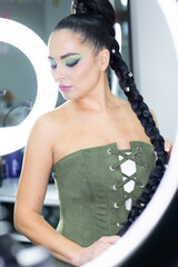 Beautiful European woman getting artistic makeup applied by a professional makeup artist in a modern beauty salon, beauty and elegance concept.