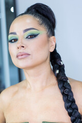 Beautiful European woman getting artistic makeup applied by a professional makeup artist in a modern beauty salon, beauty and elegance concept.