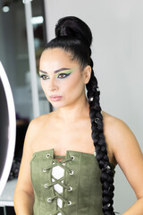 Beautiful European woman getting artistic makeup applied by a professional makeup artist in a modern beauty salon, beauty and elegance concept.