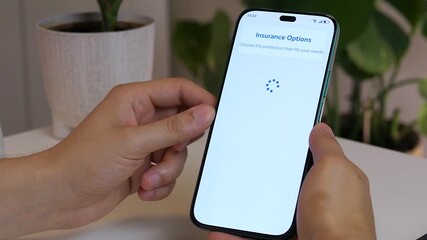 Closeup of a mans hands using a smartphone to browse an insurance marketplace, specifically finding and selecting an identity theft insurance policy to review its terms and cost.