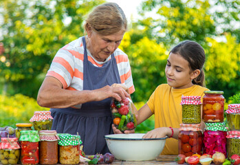 Women with jar preserved vegetables for the winter mother and daughter. Selective focus.