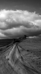Naklejka premium paysage au ciel très nuageux, photo noir et blanc format 16:9