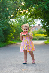 Child girl eats watermelon in summer. Selective focus.