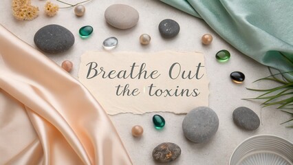 Flat lay of inspirational quote Breathe Out the Toxins with decor