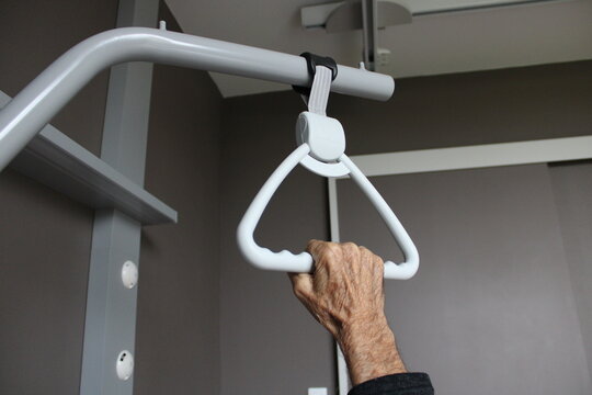 Main de personne &acirc;g&eacute;e sur un trap&egrave;ze de lit d'h&ocirc;pital, hospitalisation, soins pour les s&eacute;niors
